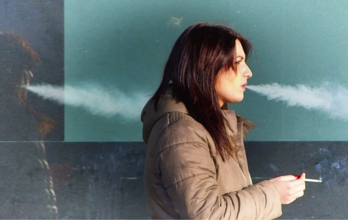 Woman in profile smoking beside a cloud image